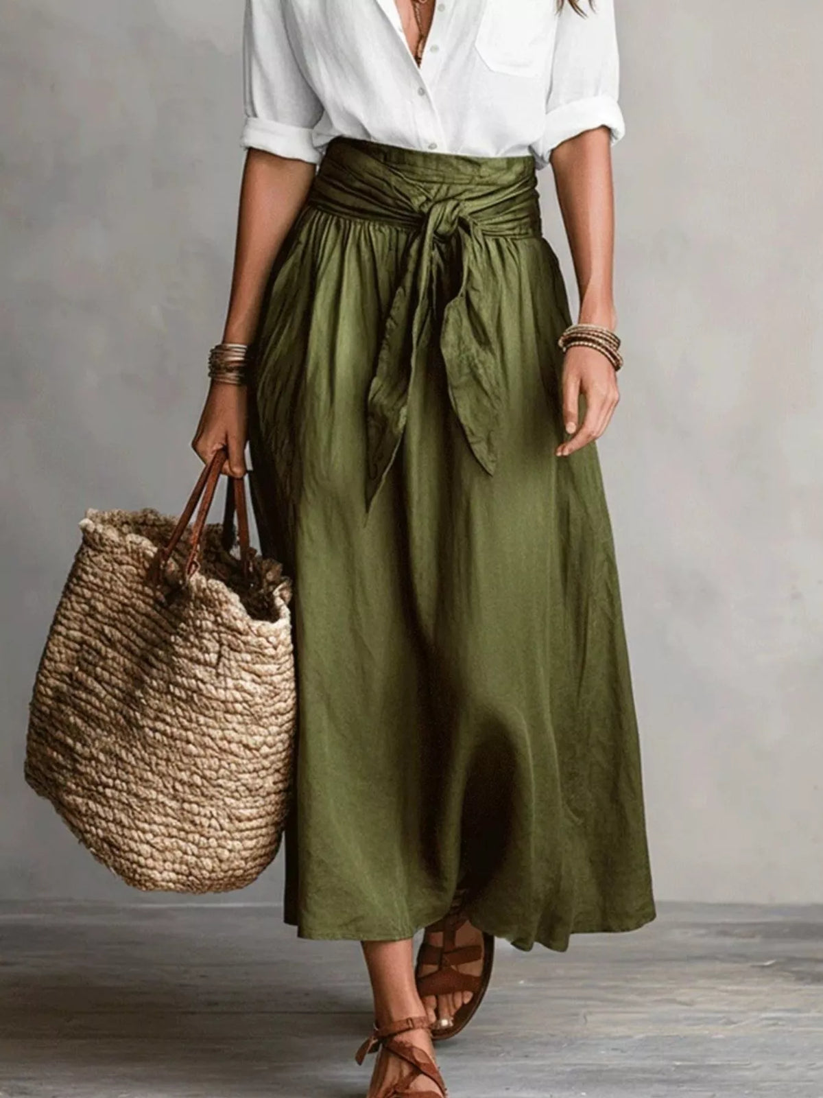 Front view of olive green midi skirt and white button-down shirt with woven tote.