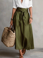 Front view of olive green midi skirt and white button-down shirt with woven tote.