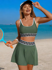 Sage green tank and skort swim set modeled holding a beach paddle