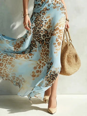 Detail of flowing sky-blue leopard-print skirt and side slit