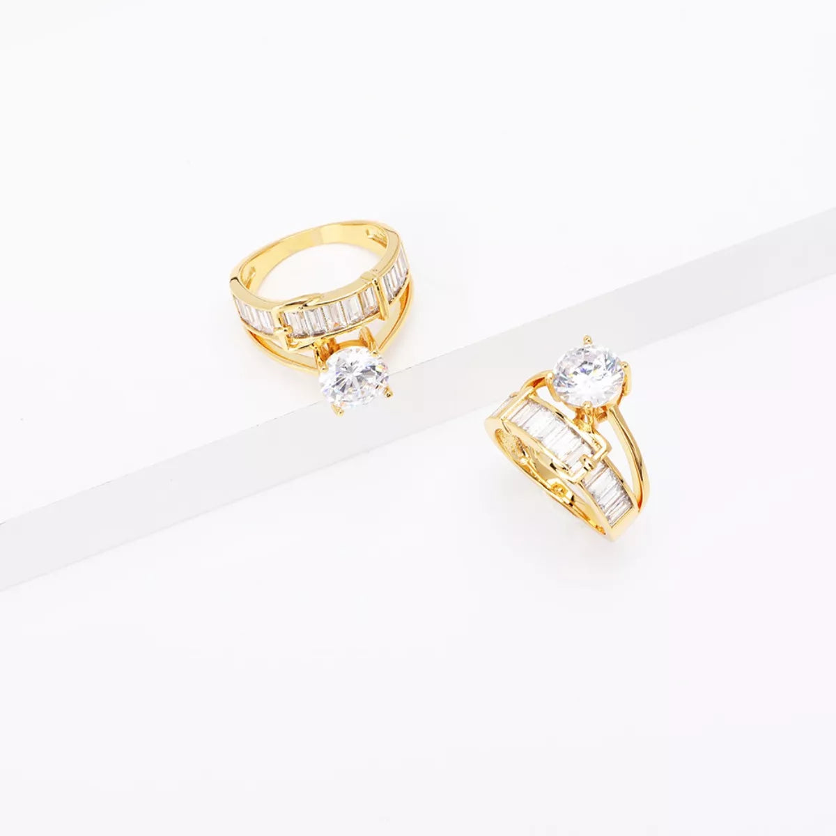 Gold-tone ring shown at an angle with its raised clear center stone