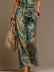 Model walking in tie-dye halter jumpsuit, showing wide-leg silhouette