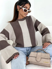 Model wearing cream and taupe colour-block sweater with light jeans and handbag