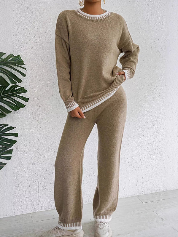 Taupe sweater and matching pants with white contrast edging, full-length front view with one hand at the hip.