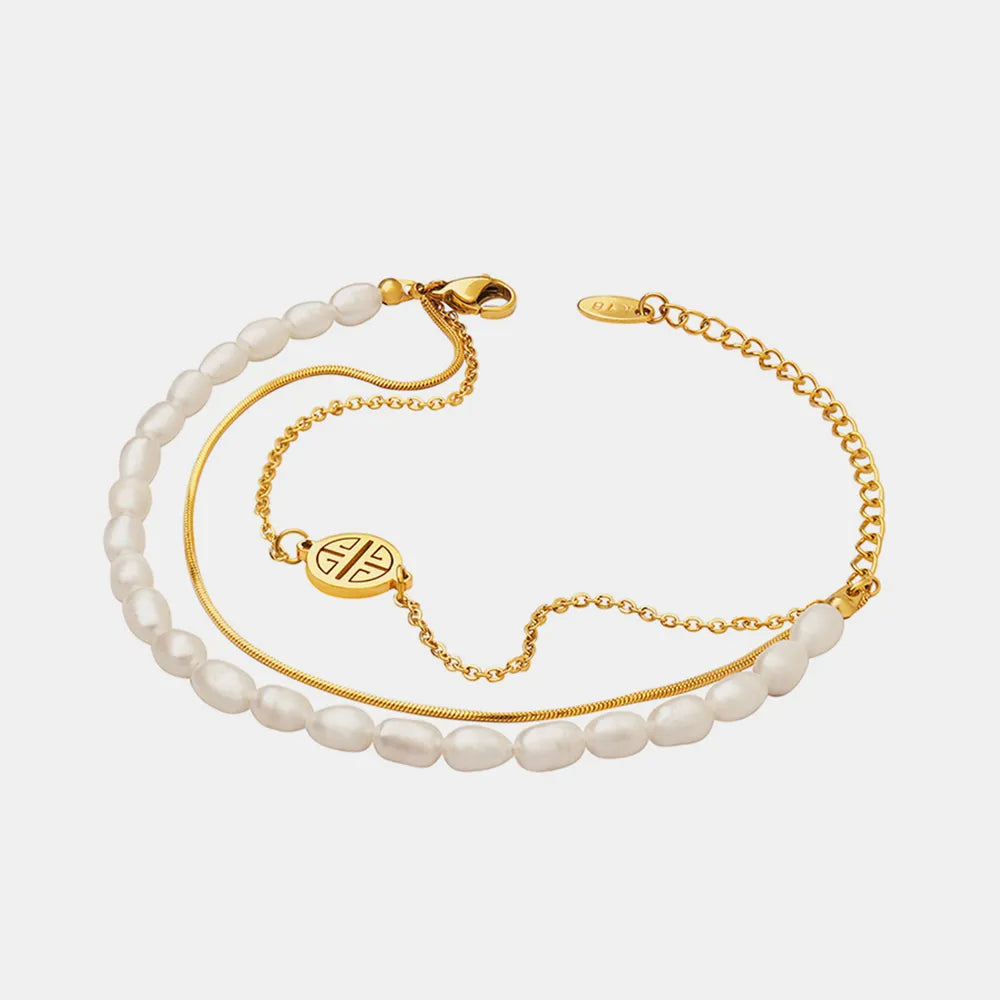 Full view of layered pearl bracelet with gold chains