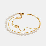 Full view of layered pearl bracelet with gold chains