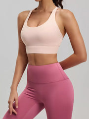 Model wearing pale pink scoop-neck active bra with pink high-waisted leggings