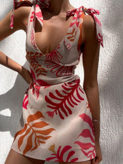 Front angled view of printed dress showing the colorful leaf pattern and gathered waist.