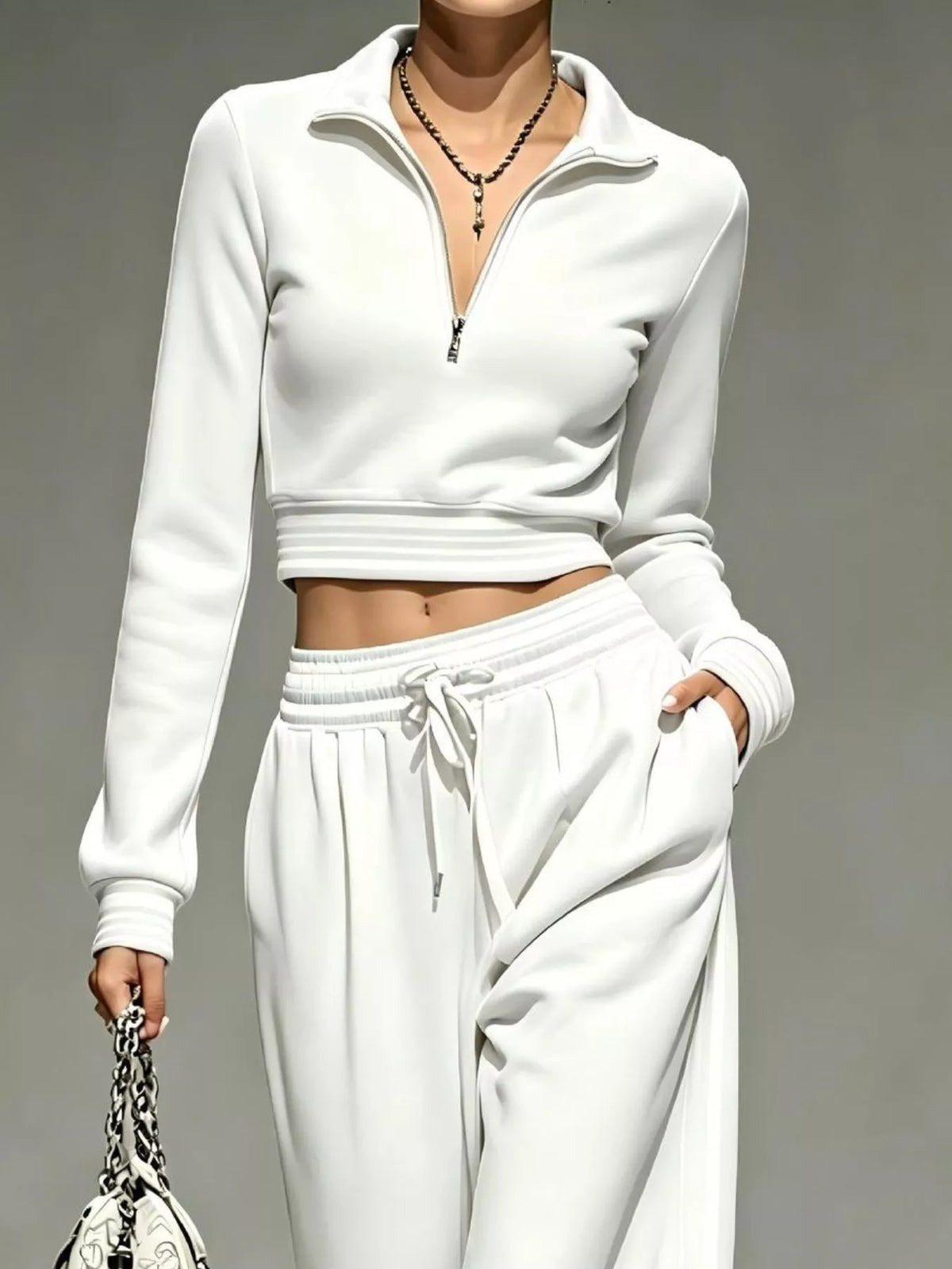 Closer view of white cropped half-zip top with striped hem and cuffs