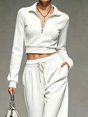 Closer view of white cropped half-zip top with striped hem and cuffs