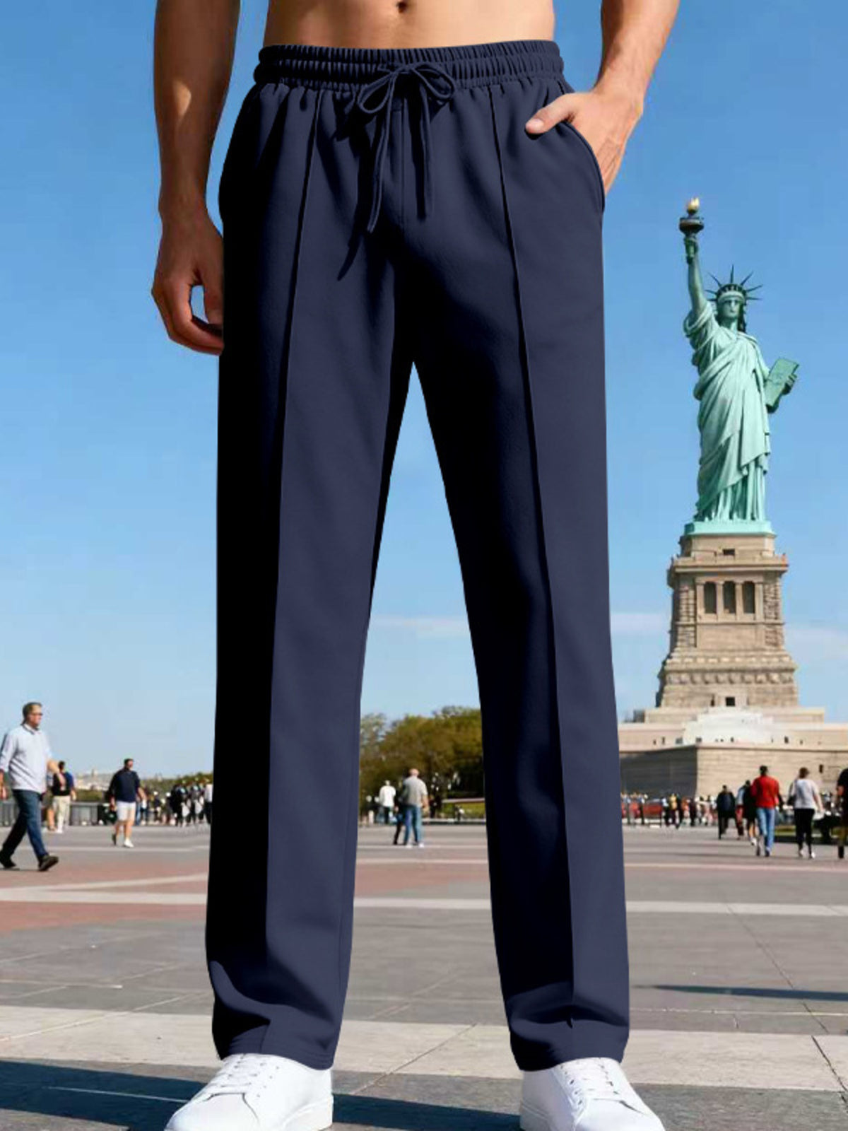Front view of navy straight-leg drawstring pants near the Statue of Liberty.