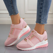 Pair of pink wedge sneakers worn with jeans