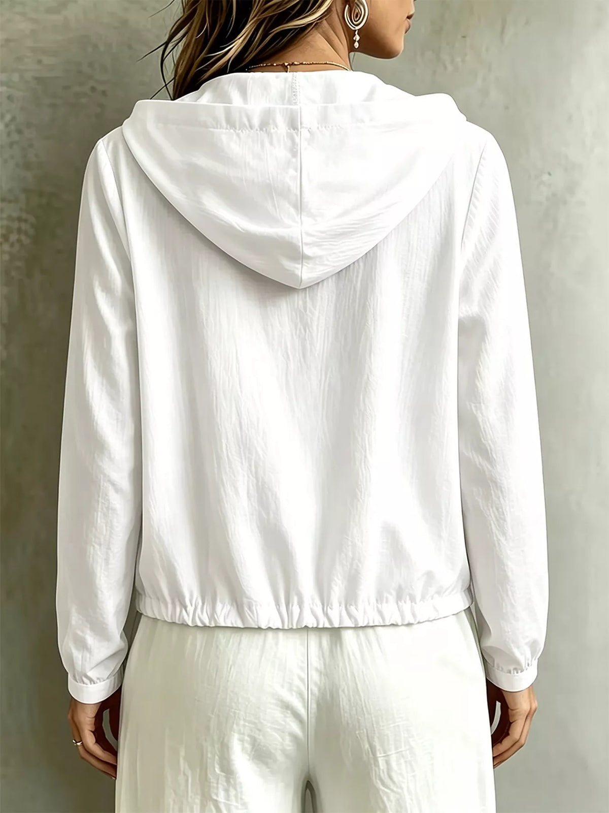 Women's white hooded long-sleeve blouse with button details and drawstring, side view