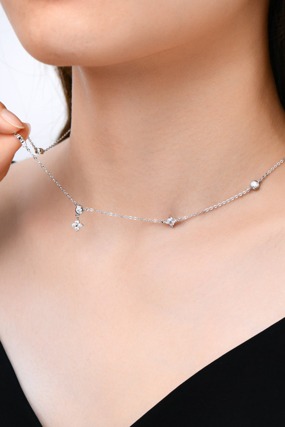 Model wearing fine silver-tone necklace with small spaced stones