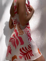 Side view of the white printed mini dress with knotted shoulder ties.