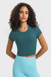 Model wearing a deep teal cropped sports T-shirt with light blue leggings
