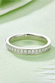 Low side view highlighting the row of stones along the silver band on green.