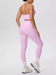Rear angled view of pink halter top and high-waisted leggings