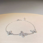 Chain bracelet with three clear-stone butterfly motifs shown at an angle