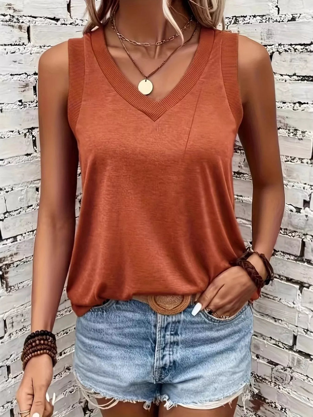 Close view of orange tank neckline and ribbed trim