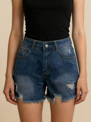 Front view of dark blue frayed-hem denim shorts with small ripped details, worn with a black top