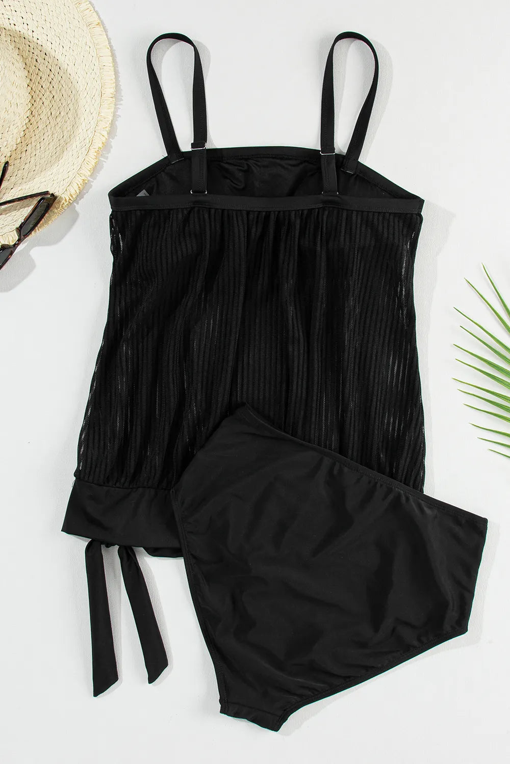 Back of black tankini top arranged flat with straps and matching briefs.