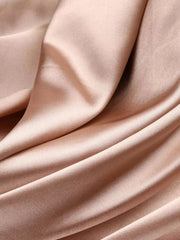Close-up of the smooth blush fabric and soft folds of the maxi dress