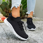 Black sneakers shown on feet with cropped jeans
