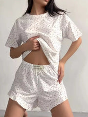 Model wearing white floral short-sleeve top and ruffled shorts lounge set