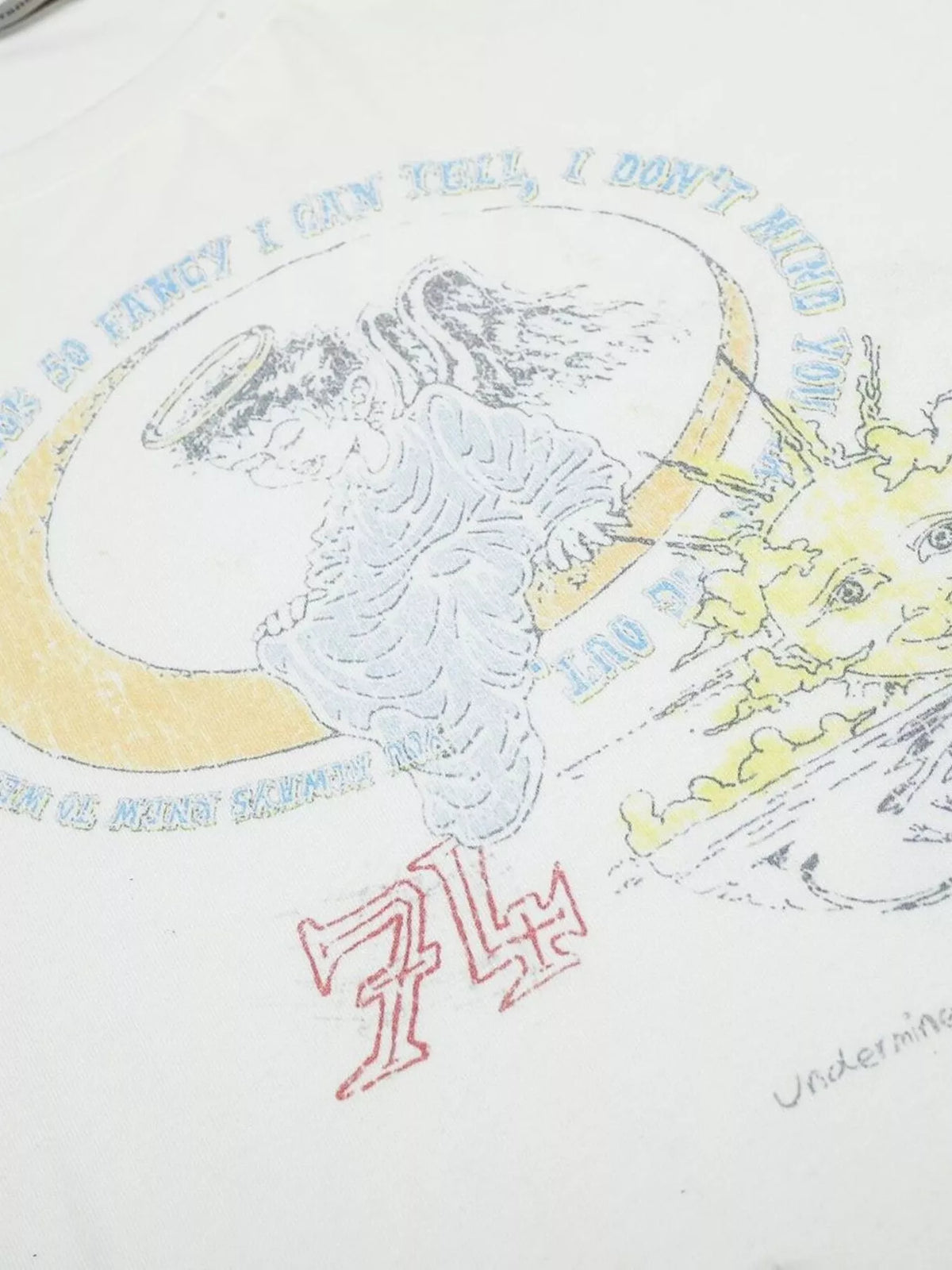 Close-up of illustrated circular graphic and lettering on white T-shirt