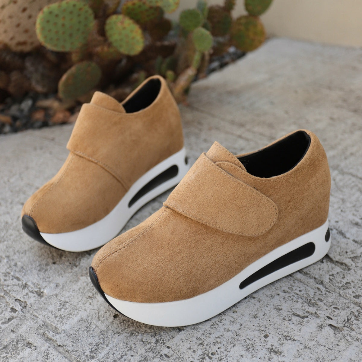 Pair of tan slip-on platform sneakers displayed together