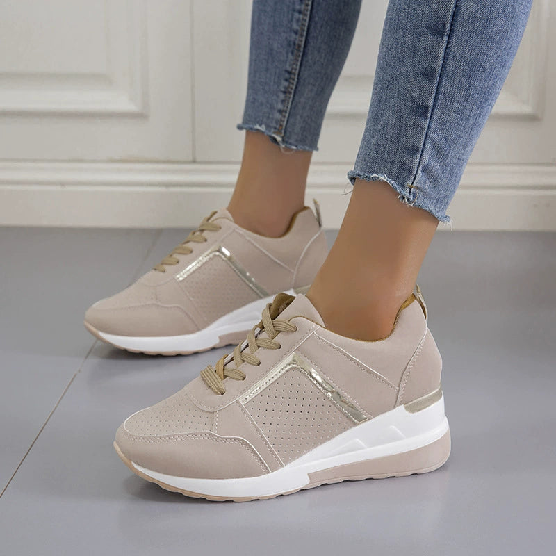 Beige wedge sneakers worn with blue jeans, side view