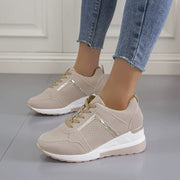 Beige wedge sneakers worn with blue jeans, side view