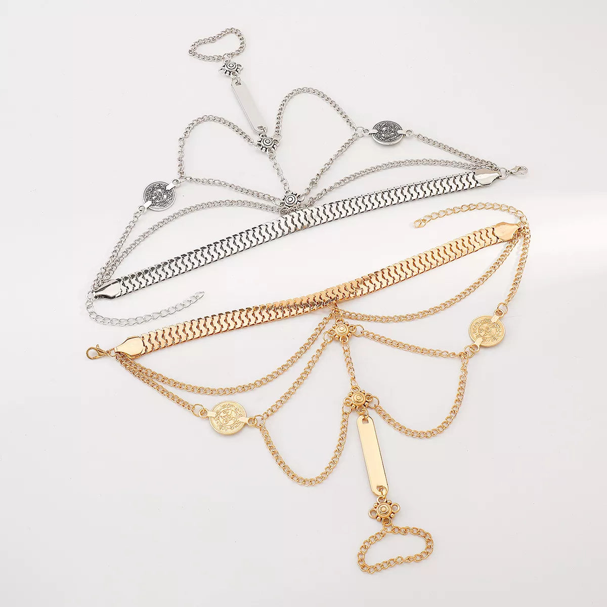 Gold-tone hand chain bracelet with linked finger ring laid flat