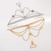 Gold-tone hand chain bracelet with linked finger ring laid flat