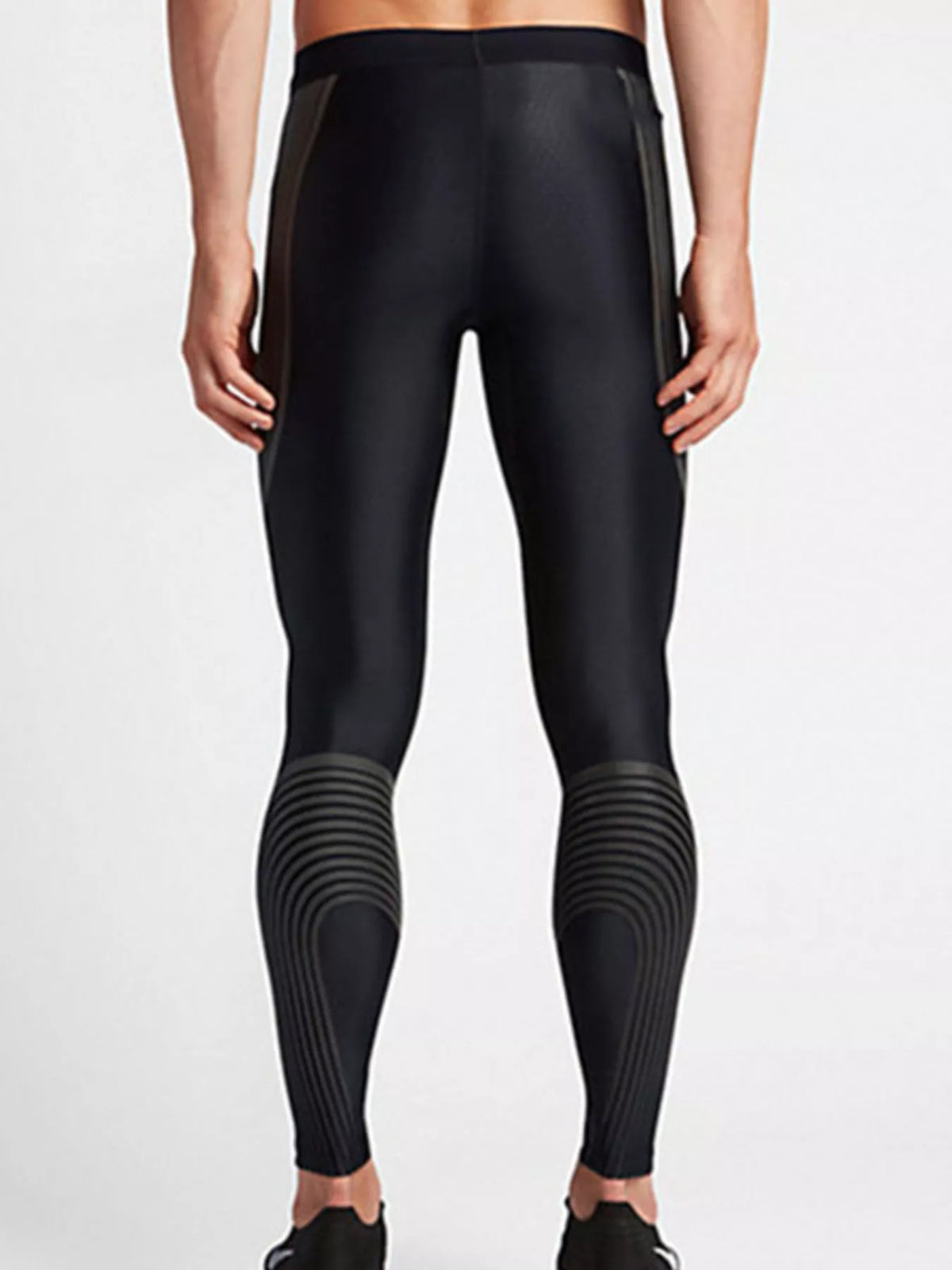 Back view of black active leggings with curved gray calf detailing