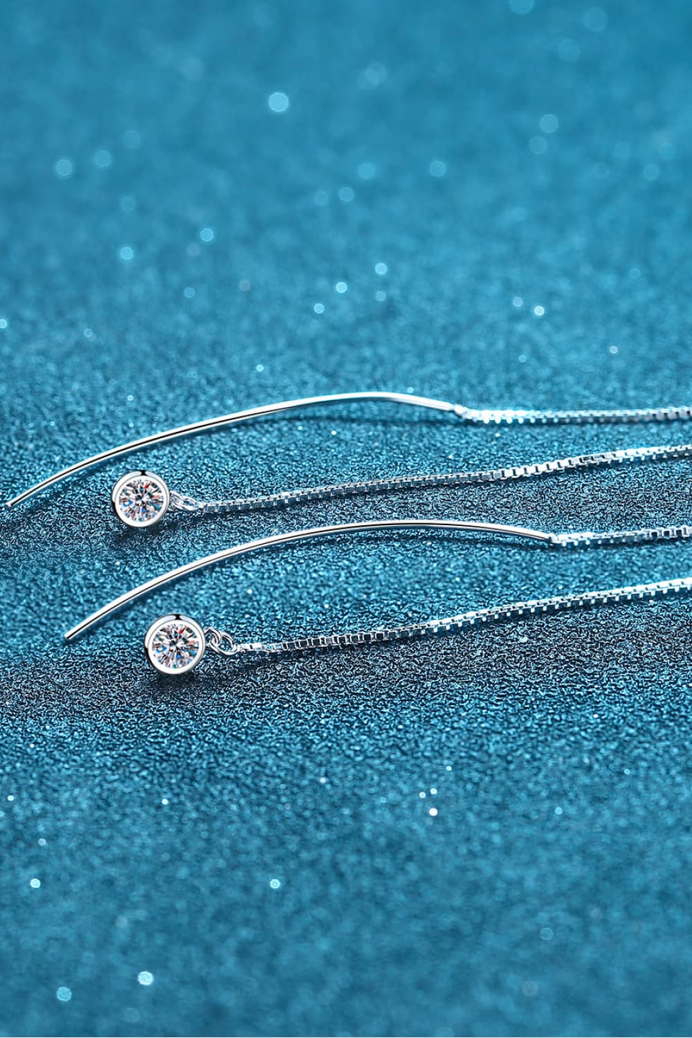 Moissanite 925 Sterling Silver Threader Earrings — Pair of threader earrings shown horizontally on blue display