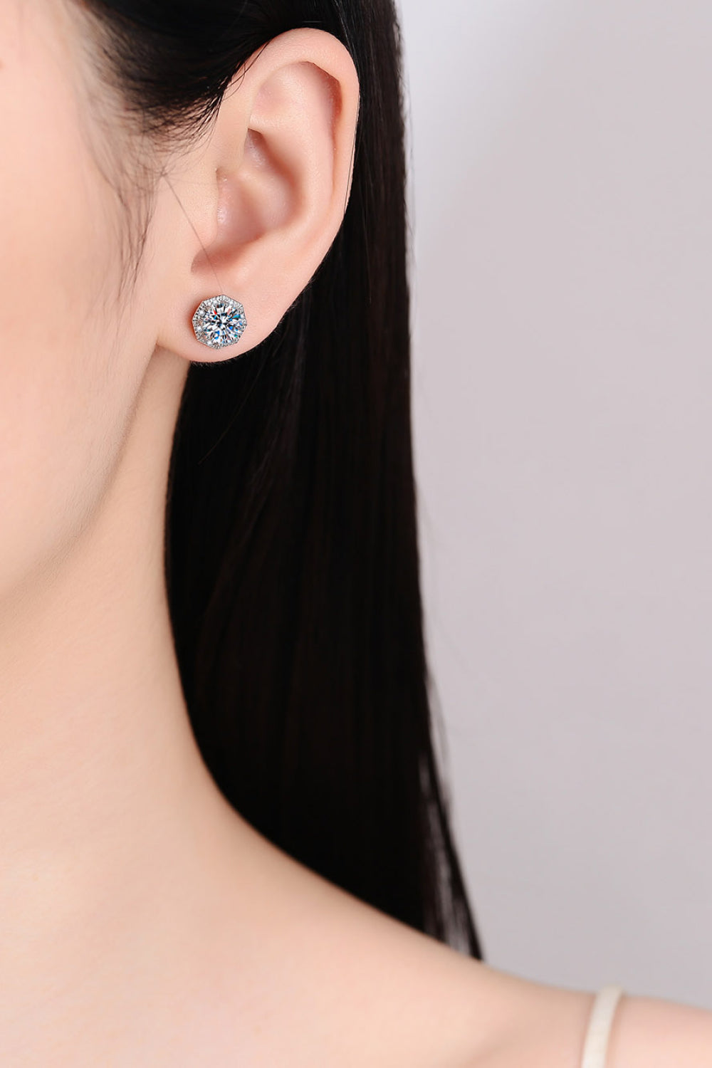 Round moissanite stud earring worn on ear