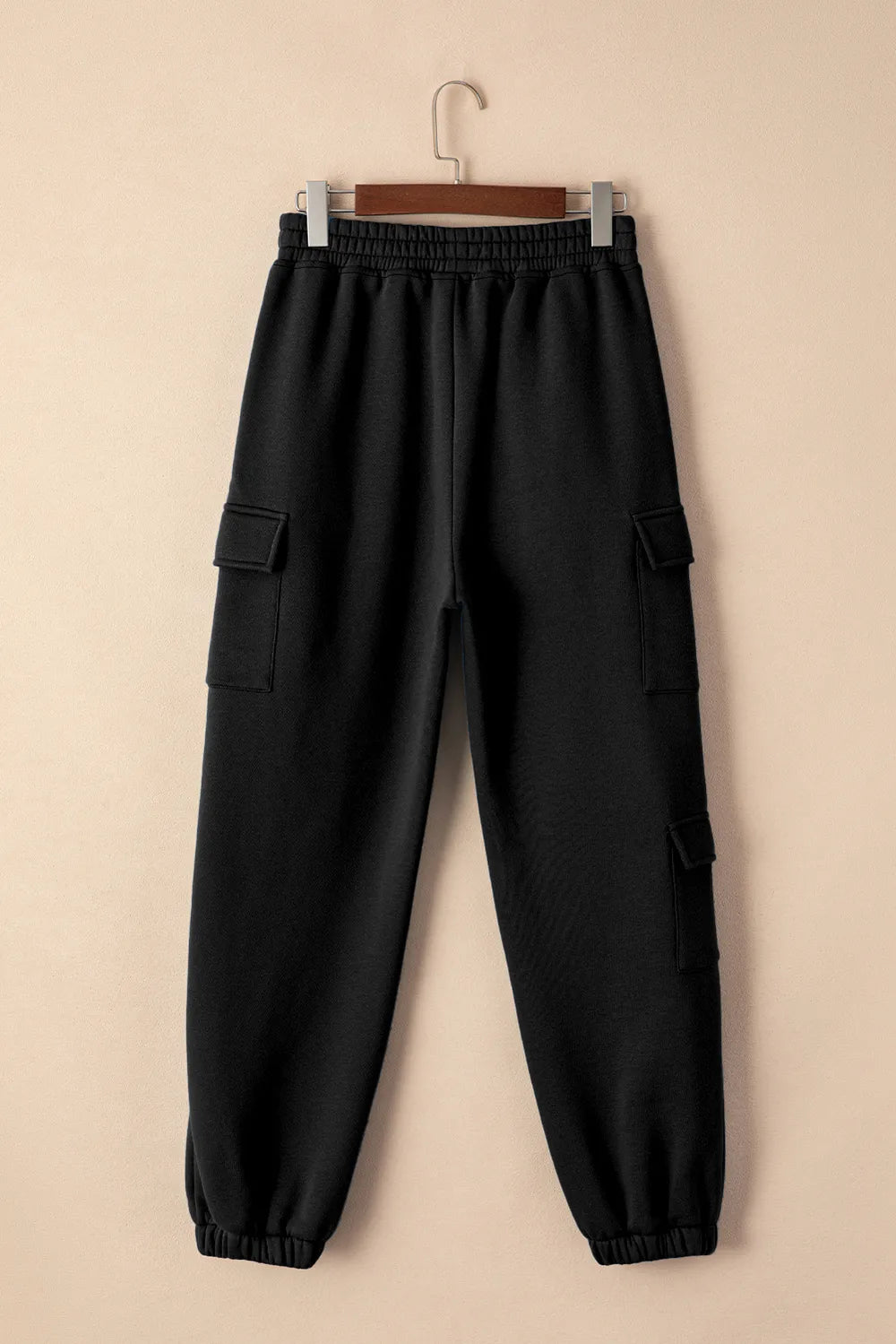 Back view of black joggers with elastic waist and cargo pockets