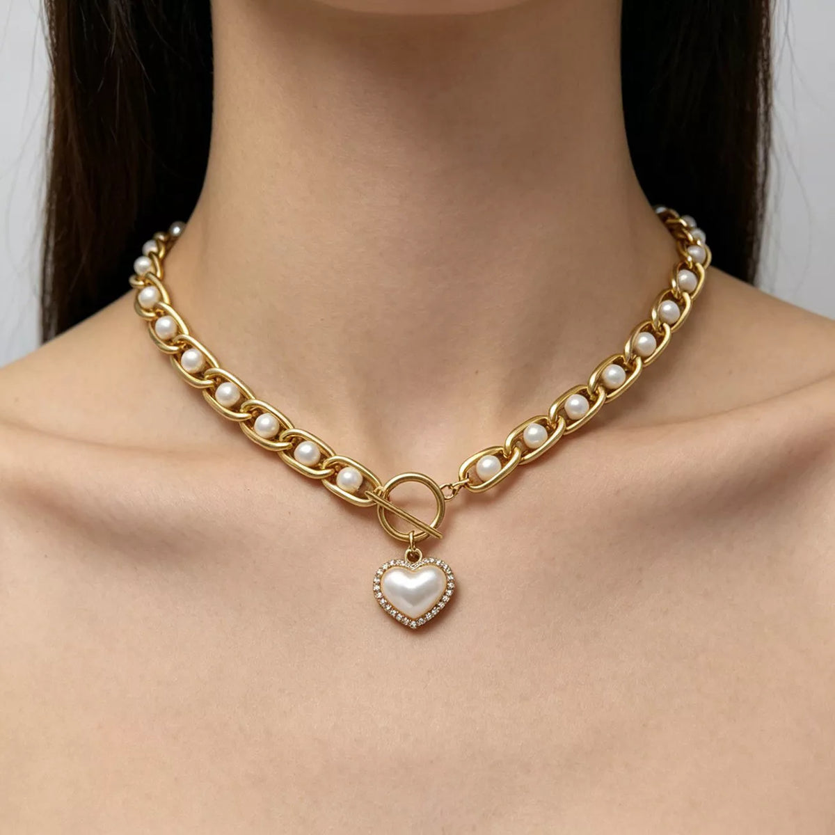 Front view of pearl chain necklace with heart pendant worn at the neck