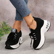 Black mesh lace-up platform sneakers worn with jeans, showing chunky sole