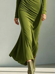 Lower view of the green ruched dress showing its flowing flared hem.