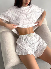 Seated model wearing the floral lounge set, showing the shorts and top