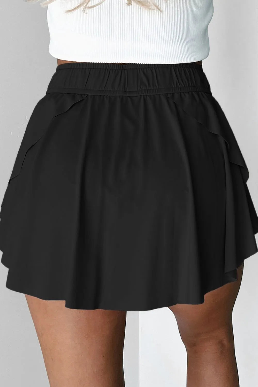 Black skort lifted to reveal the fitted shorts underneath