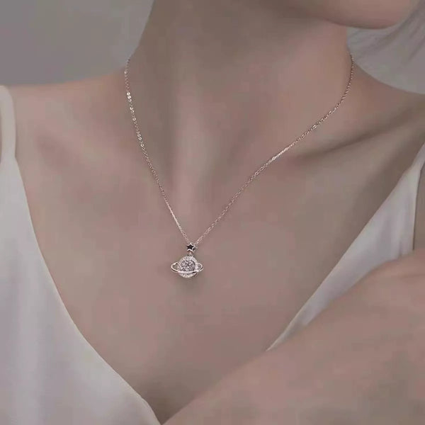 Silver planet pendant necklace worn at the neckline