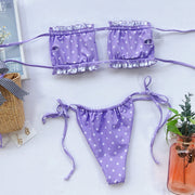 Lavender polka-dot bikini laid flat with the inside of the frill-trim top visible