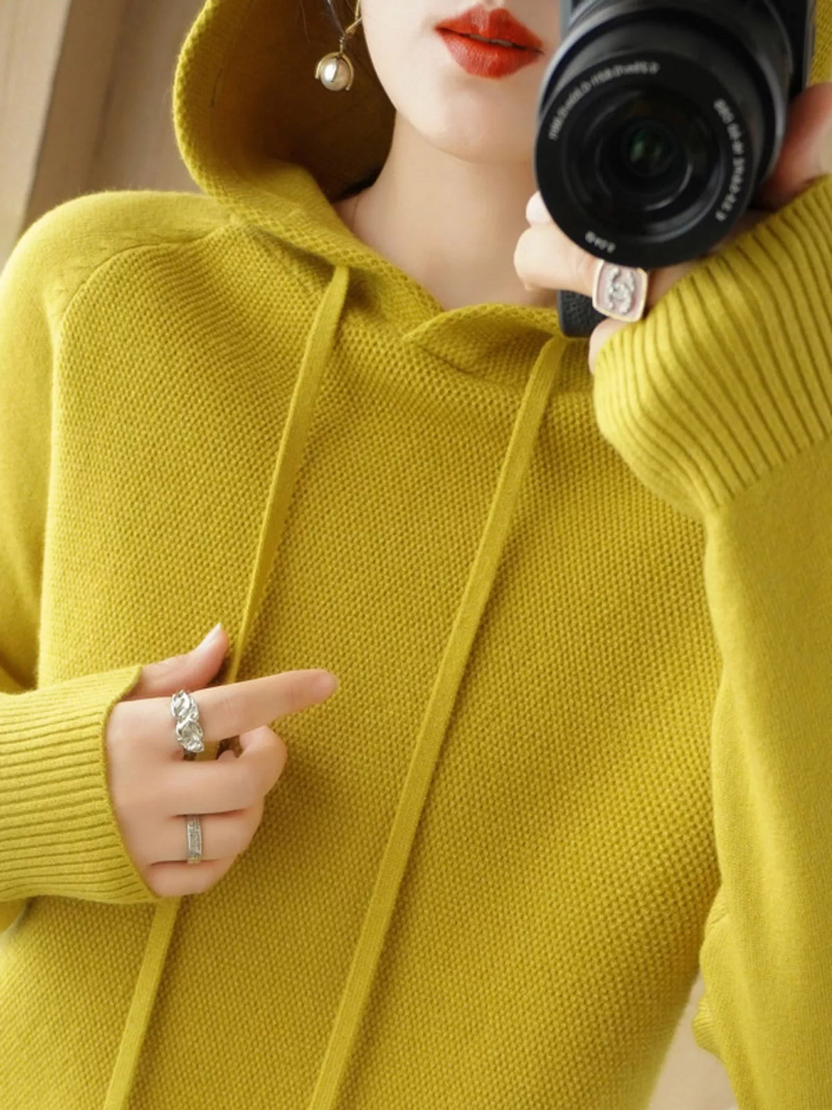 Mustard-yellow hooded knit sweater shown in a close mirror photo.