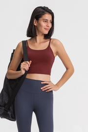 Model wearing a burgundy cami and navy leggings, carrying a black shoulder bag.