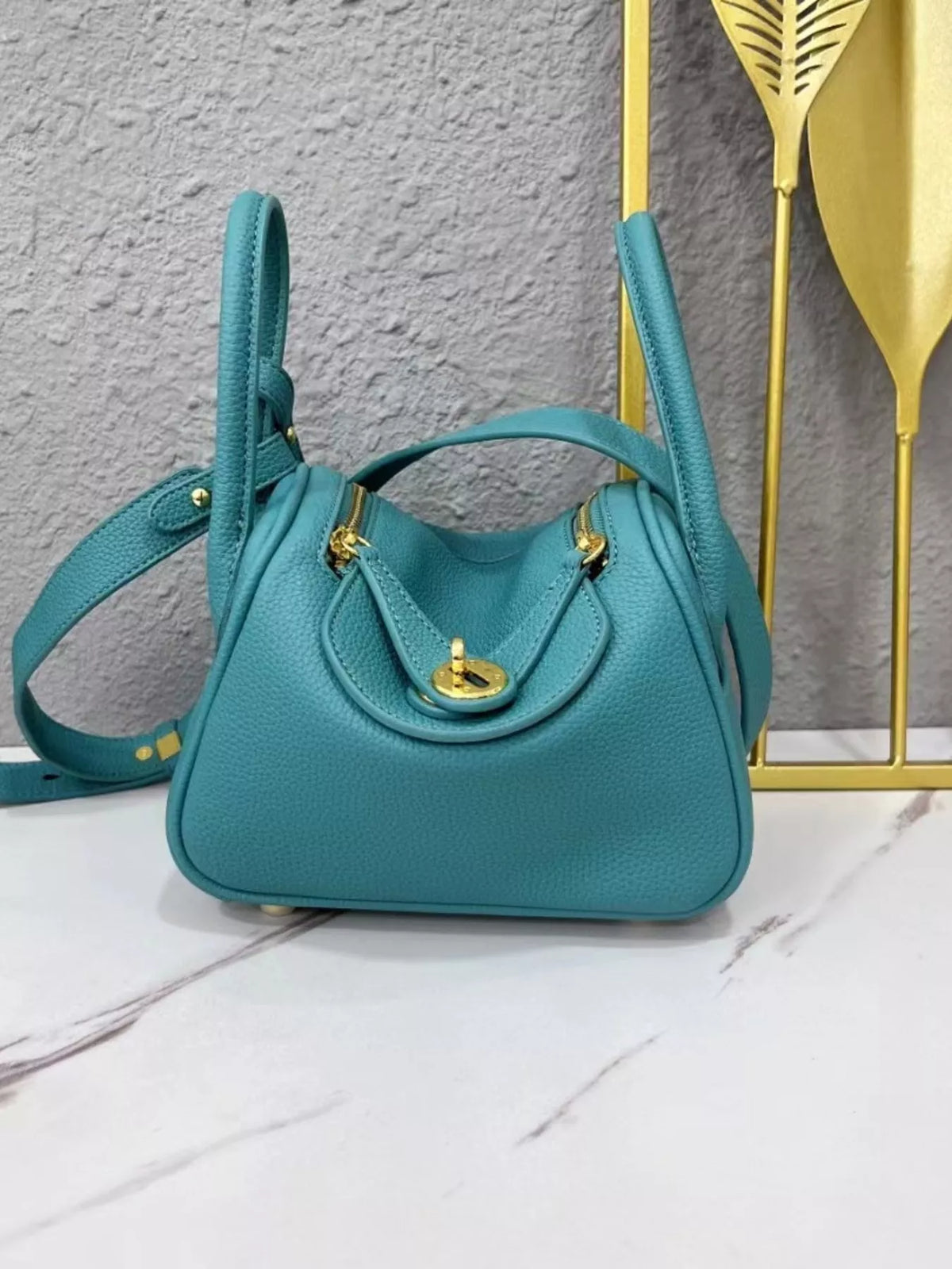 Teal pebbled crossbody bag with gold-tone hardware, front view