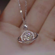 Close-up of round moissanite planet pendant with orbit ring and star detail